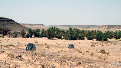 Dos vehículos 4x4 en un paisaje desértico de arena durante una ruta 4x4 por Marruecos.