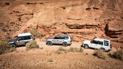 Tres vehículos 4x4 circulando por un rio seco en el desierto de Marruecos.