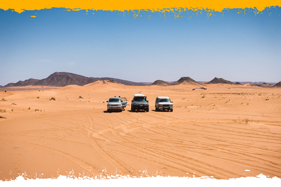 Tres 4x4 en un paisaje desértico de arena durante una ruta 4x4 por Marruecos.