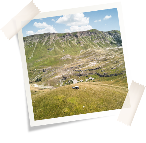 Imagen desde un dron de un 4x4 en los prados verdes de montaña en Montenegro durante una ruta por los Balcanes.