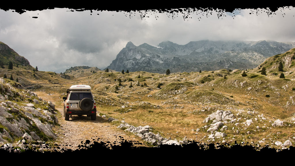 Un 4x4 en las montañas pedregosas de Montenegro durante una ruta por los Balcanes.