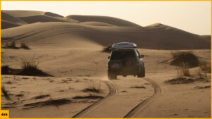 Atardecer con un 4x4 en las dunas de arena de Merzouga durante una ruta 4x4 por el desierto del sur Marruecos.