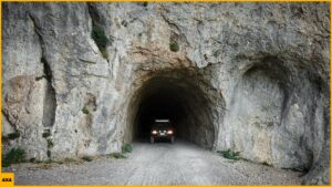 Un vehículo 4x4 circulando por un túnel excavado en la montaña durante una ruta en 4x4 por Croacia en los Balcanes